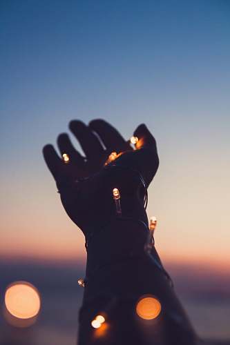 android wallpapers person showing left hand with string lights android backgrounds